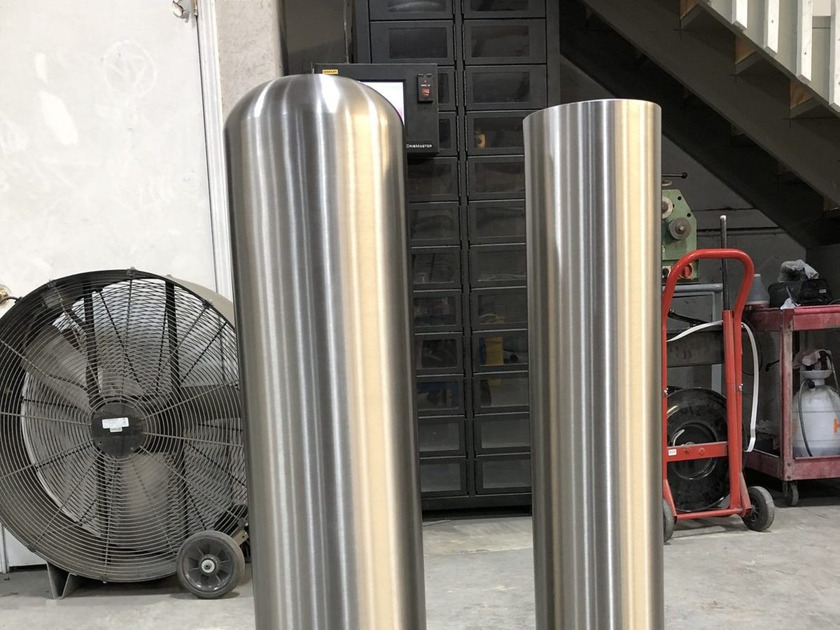 Brushed stainless steel flat-top and dome-top bollard covers side by side
