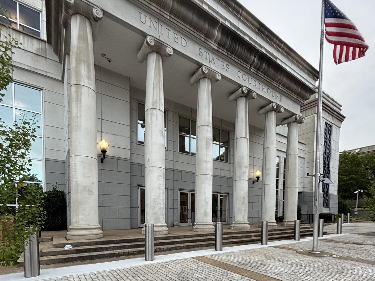 Brushed stainless steel grooved reveal bollard covers lining the columned entrance of a United States federal courthouse