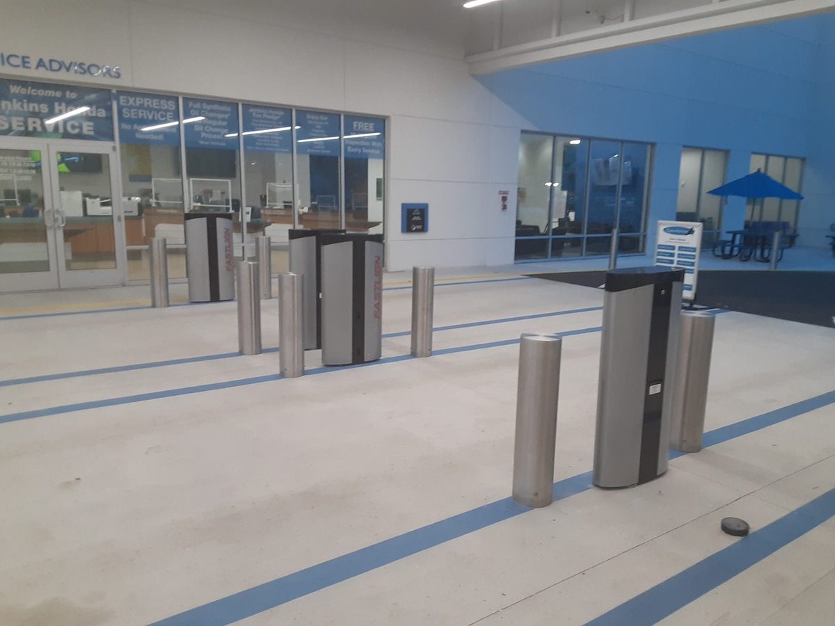 Stainless steel bollards with branded covers at a Honda dealership service entrance