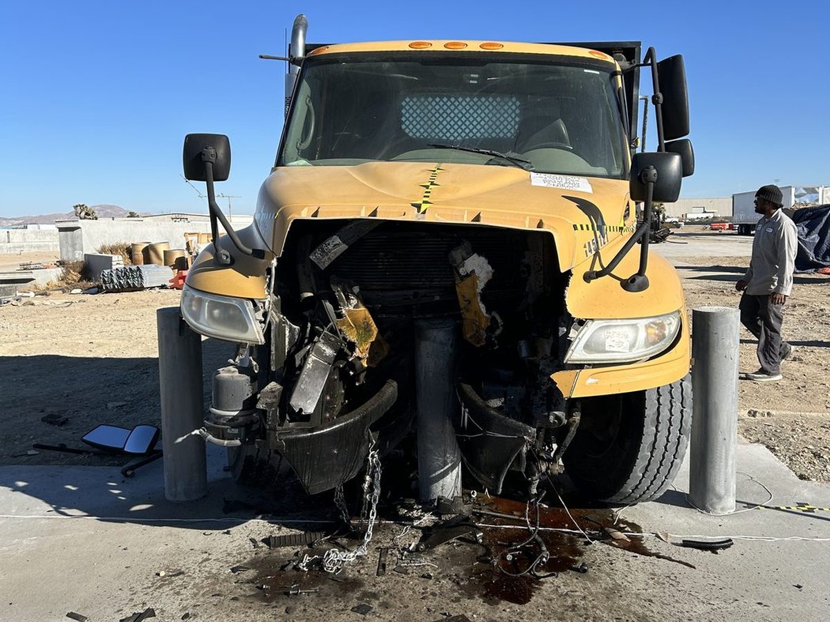 Medium-duty truck with its front end destroyed after being stopped by an ASTM M30 crash-rated bollard