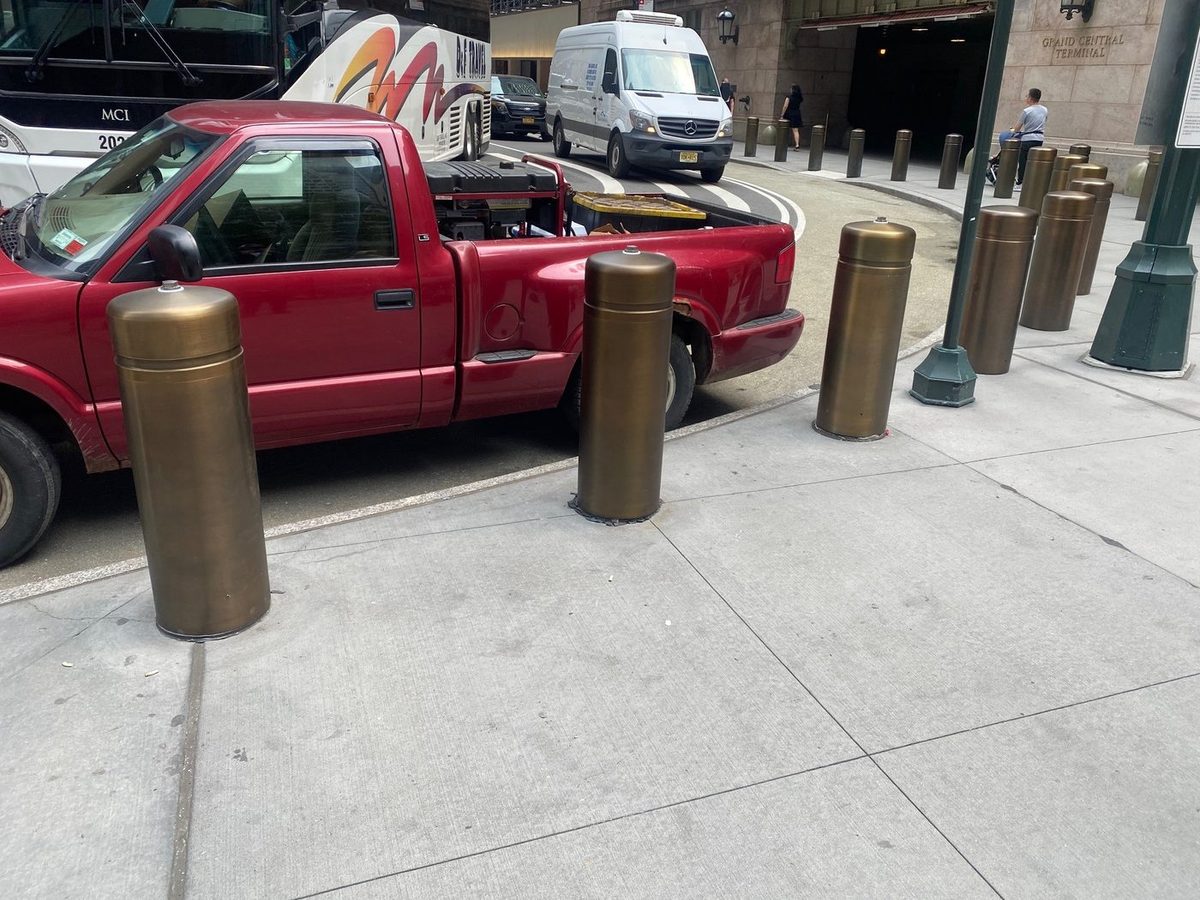 Bronze dome-top bollard covers protecting the sidewalk at One Vanderbilt near Grand Central Terminal, New York City