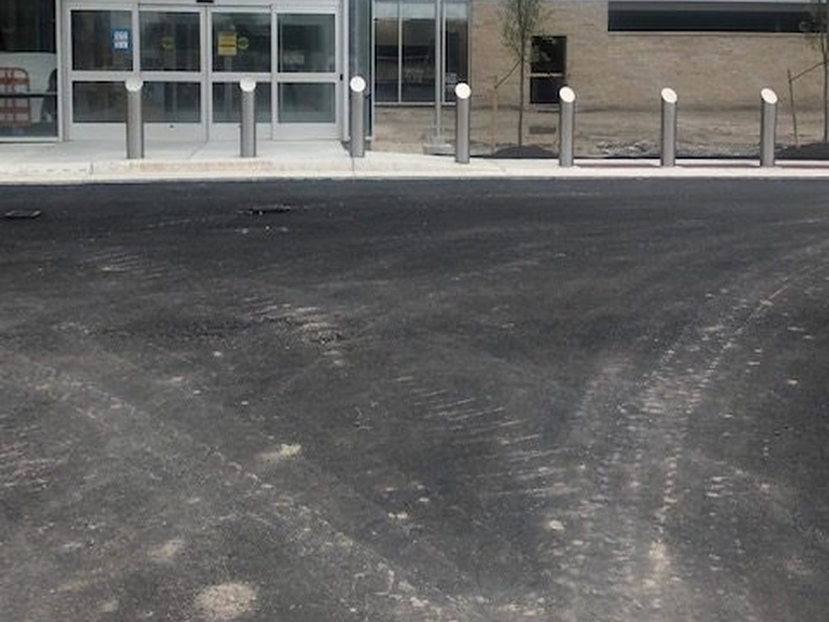Stainless steel dome-top bollards with reflective bands at the glass entrance of Sentara Hospital