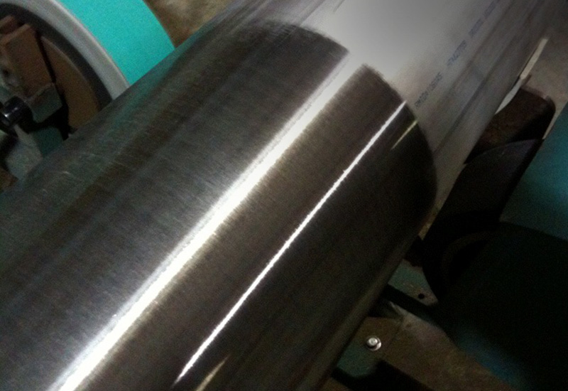 Close-up of brushed stainless steel polishing process creating #4 finish