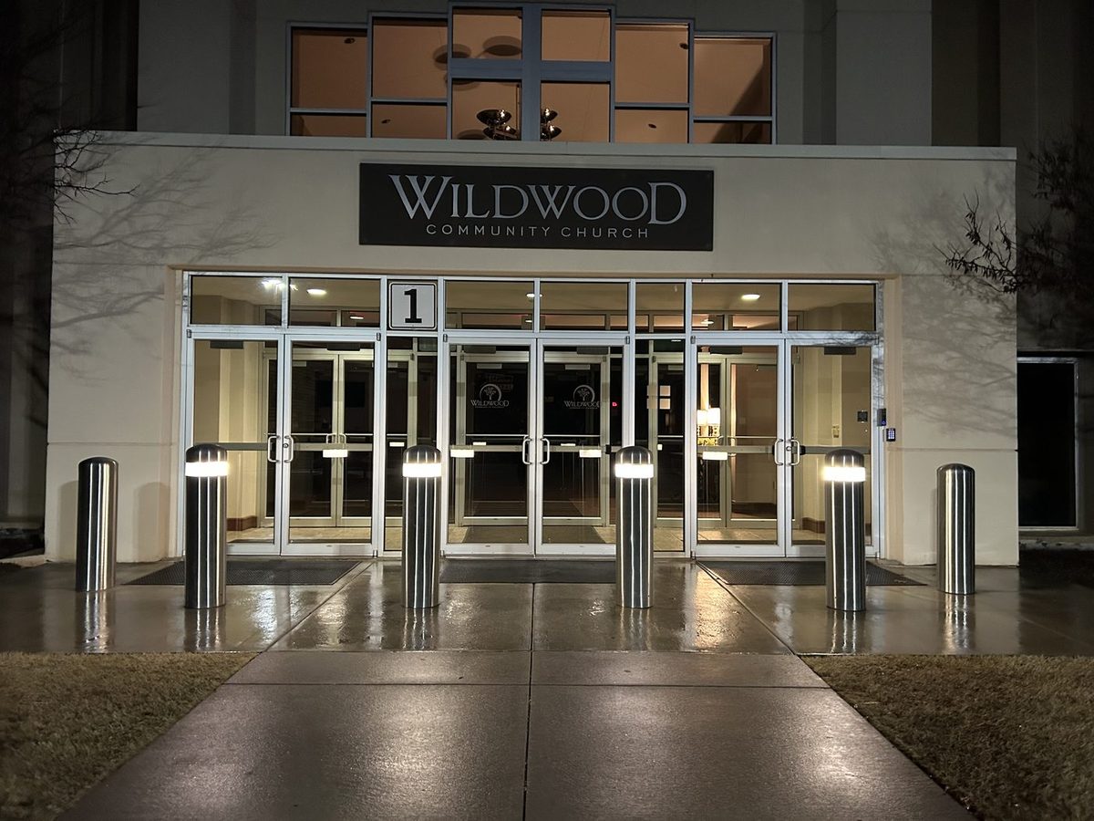 LED-illuminated polished stainless steel dome-top bollards at the Wildwood Community Church entrance at night